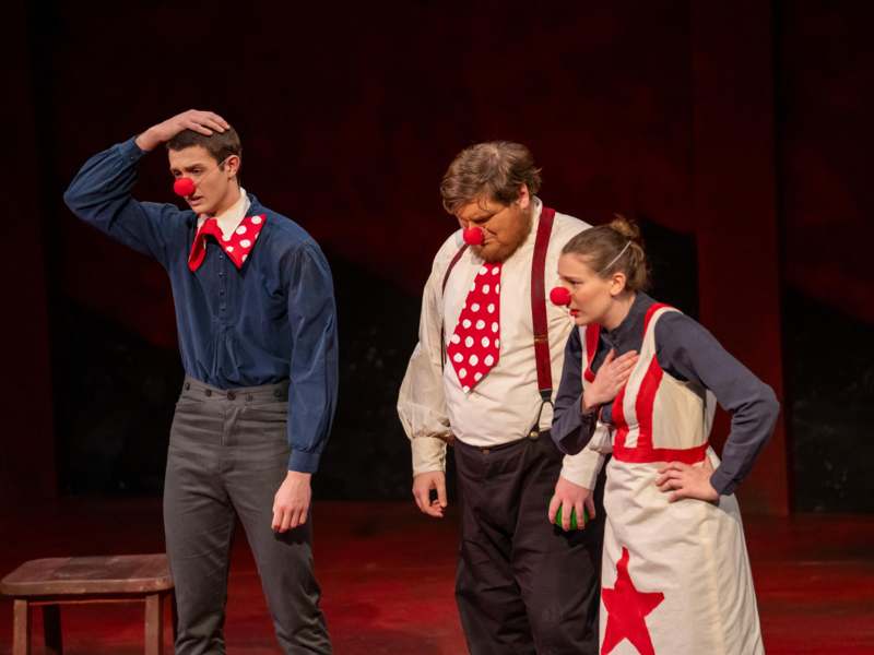 a group of people with red clowns on a stage