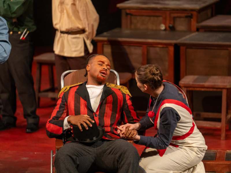 a man sitting in a chair holding a woman's hand