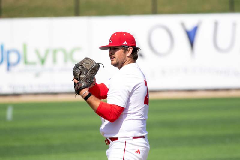 a baseball player in a red hat and white uniform
