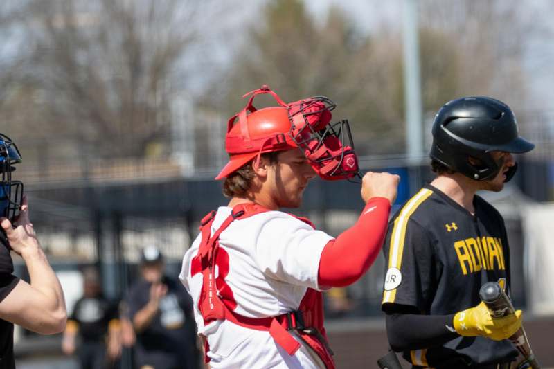 a baseball player putting on a helmet