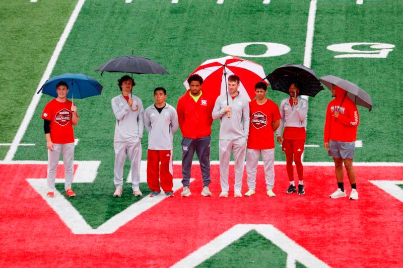 a group of people holding umbrellas on a football field