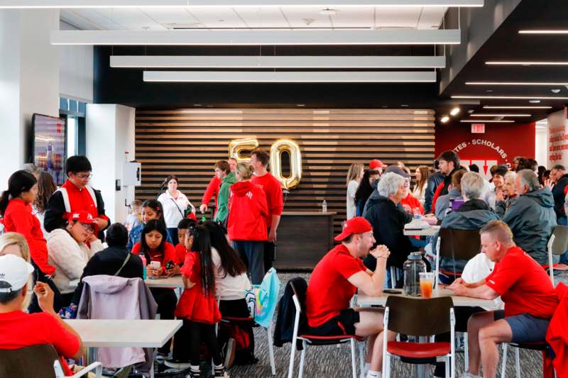 a group of people sitting at tables in a room with a sign