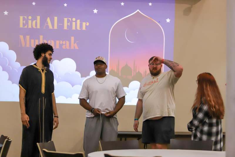 a group of people standing in front of a screen