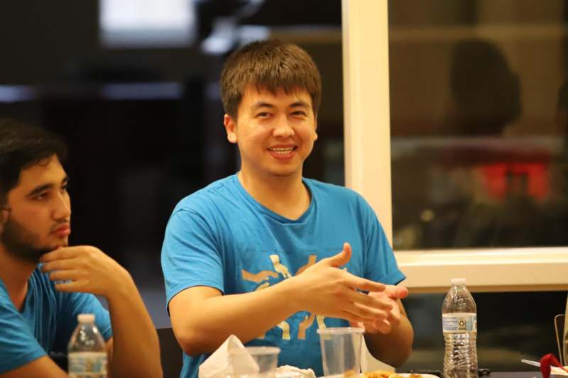 a man sitting at a table with food and a bottle of water