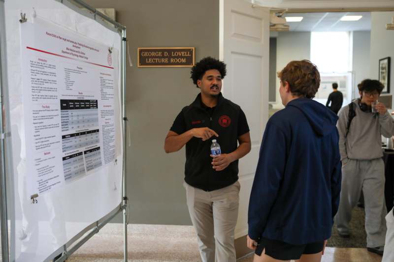 a man standing next to a man holding a water bottle