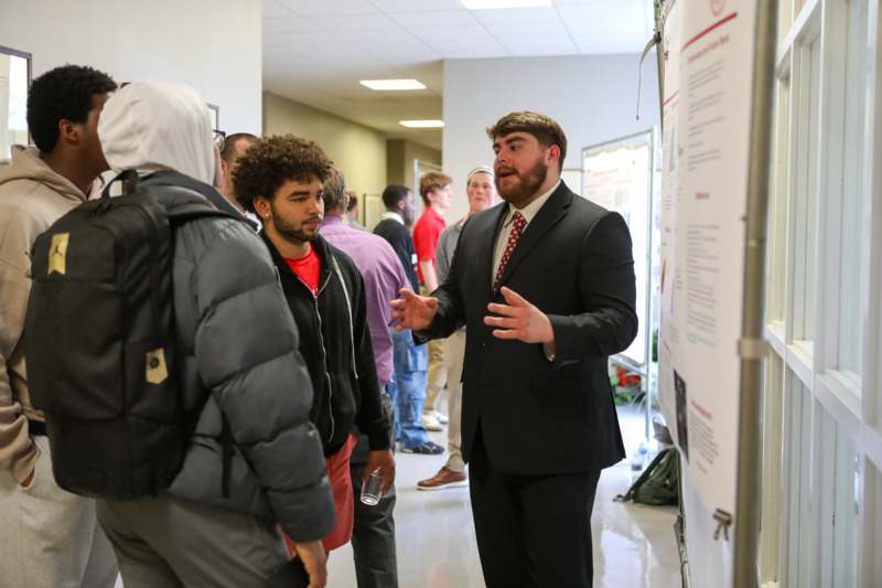 a man in a suit talking to a group of people