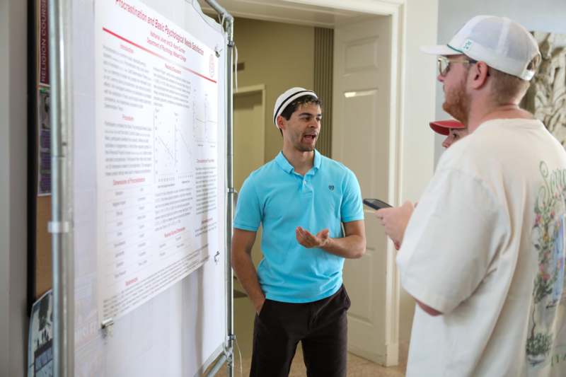 a group of men standing in front of a poster