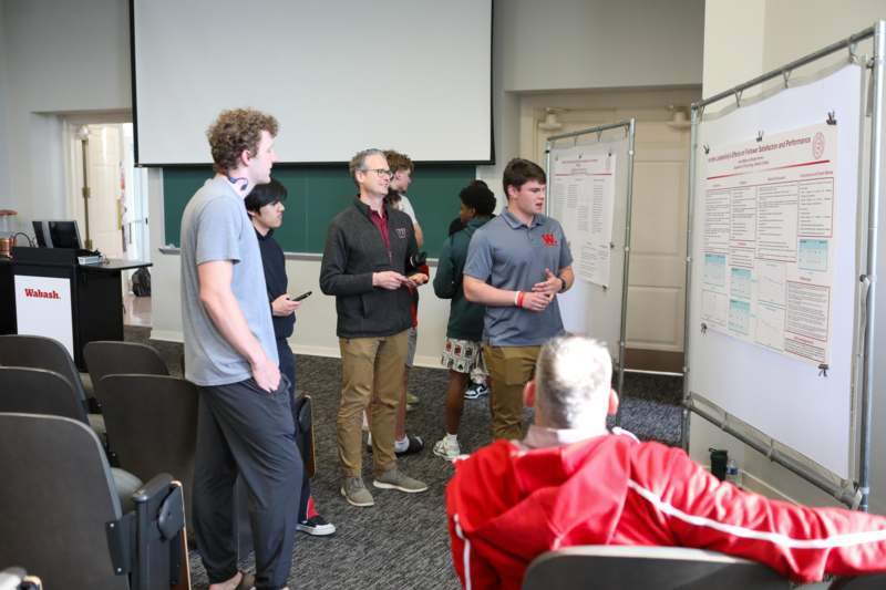 a group of people standing in front of a whiteboard