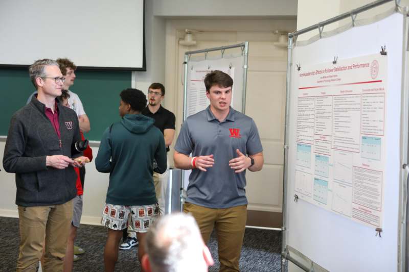 a group of people standing in front of a white board