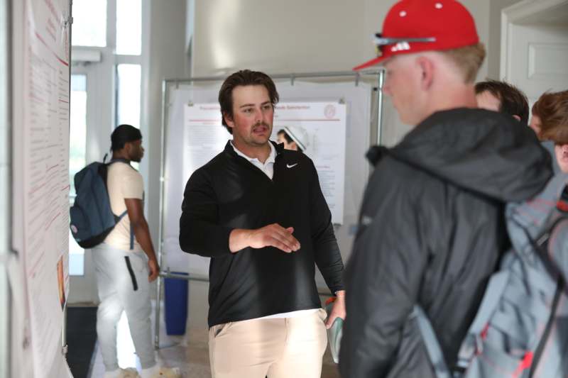a man talking to a man in a red hat
