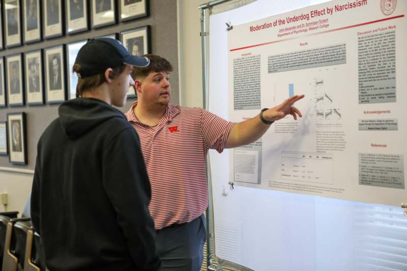 a man pointing at a poster