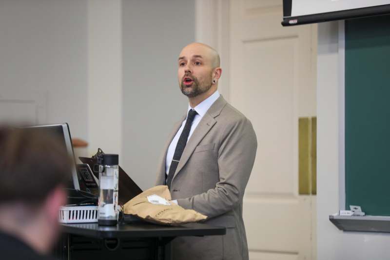 a man in a suit standing next to a desk