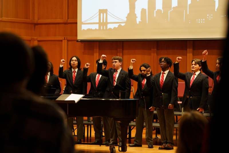 a group of people in suits and ties performing on stage