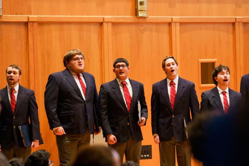 a group of men in suits and ties singing