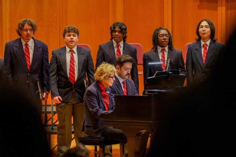 a group of people in suits and ties performing a song
