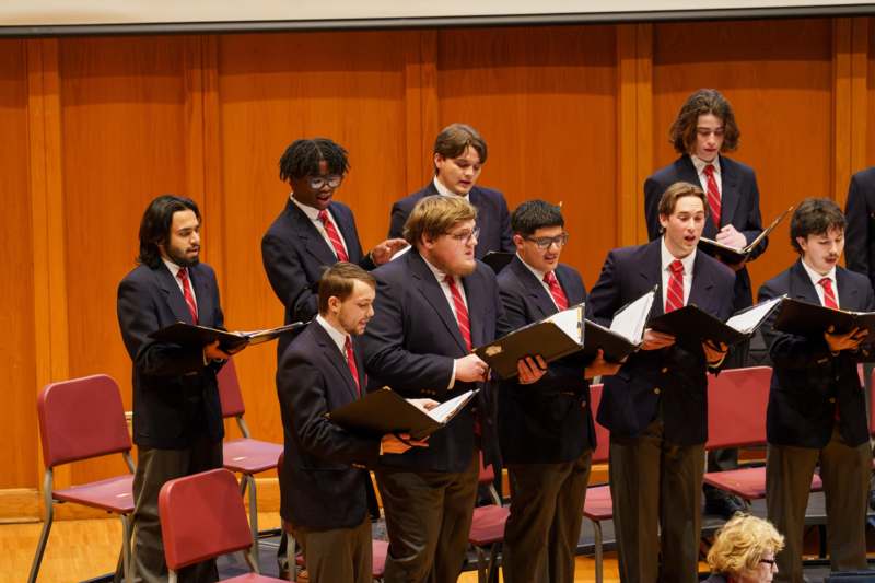 a group of men singing in a choir