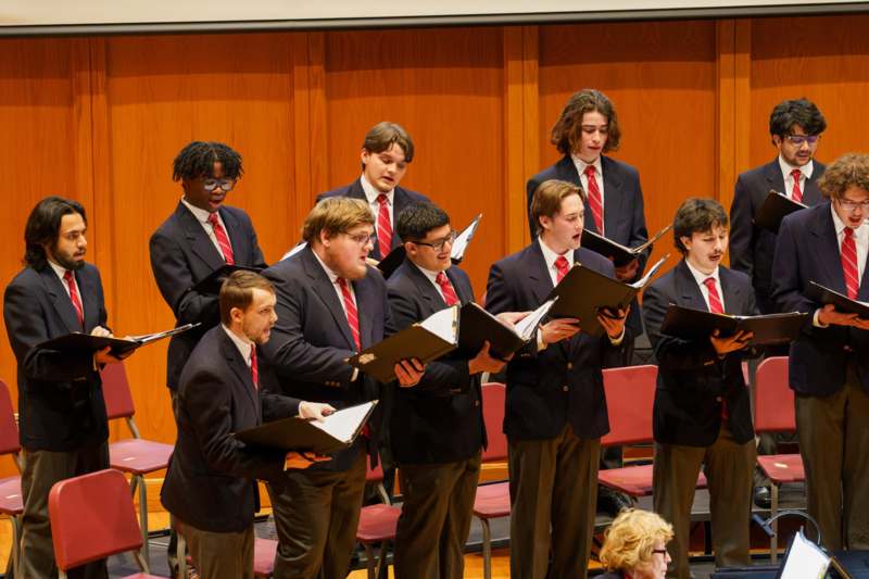 a group of men singing in a choir