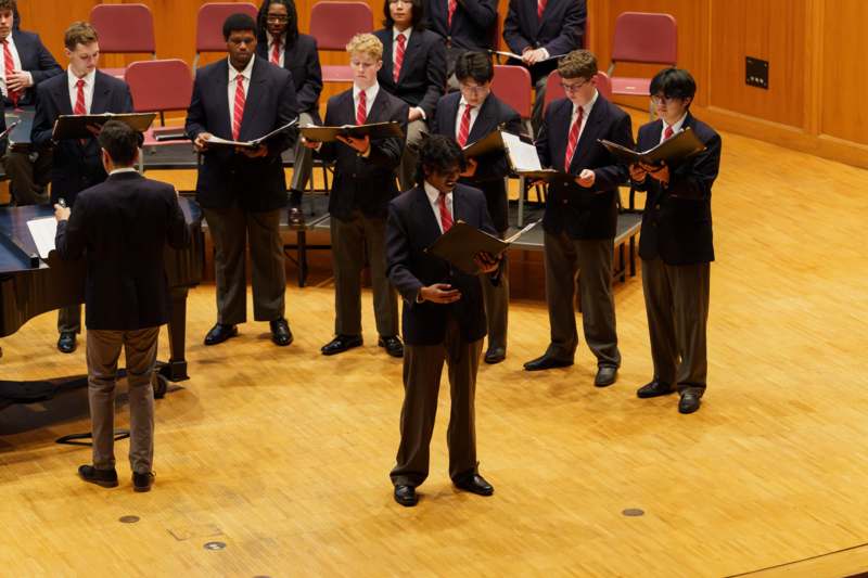 a group of people in suits and ties standing in a circle