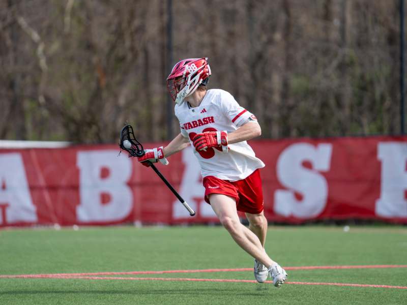 a man in a helmet holding a lacrosse stick