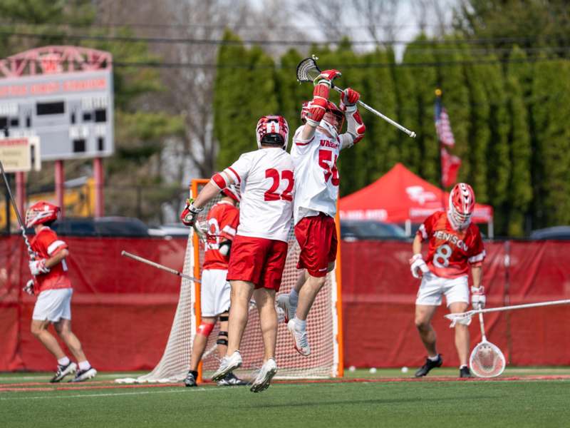a group of people jumping in the air with sticks