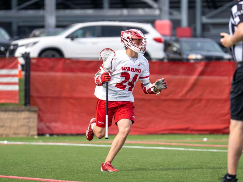 a man wearing a helmet and holding a lacrosse stick