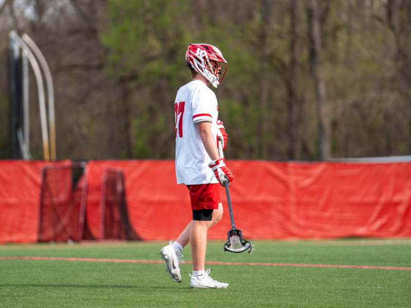 a man wearing a helmet and holding a lacrosse stick