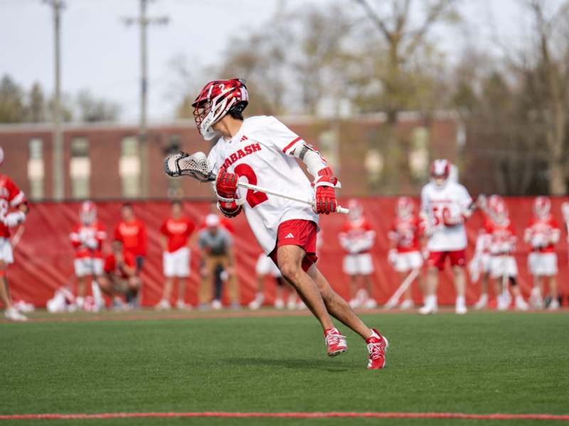 a man in a lacrosse uniform running on a field