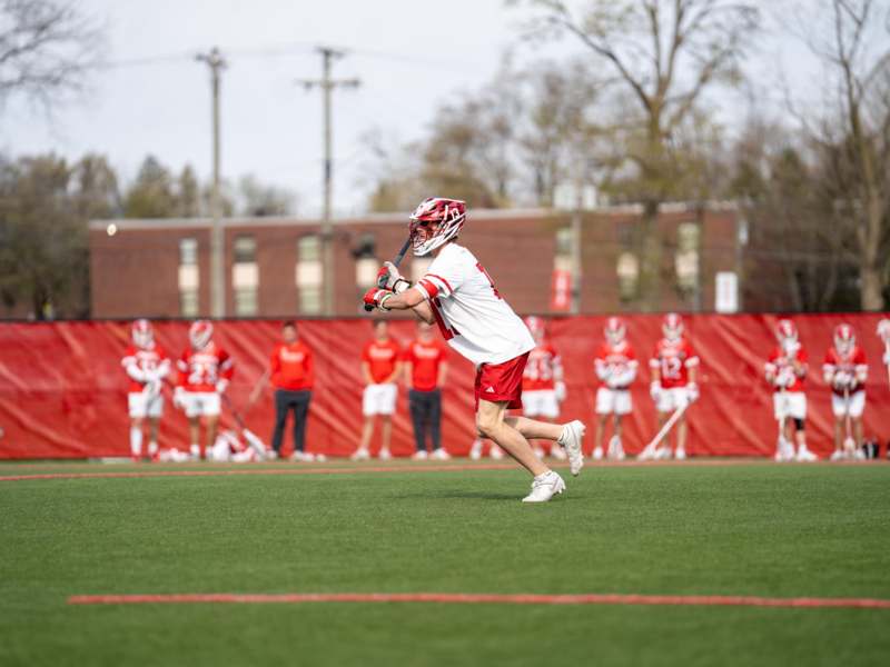 a boy playing lacrosse on a field