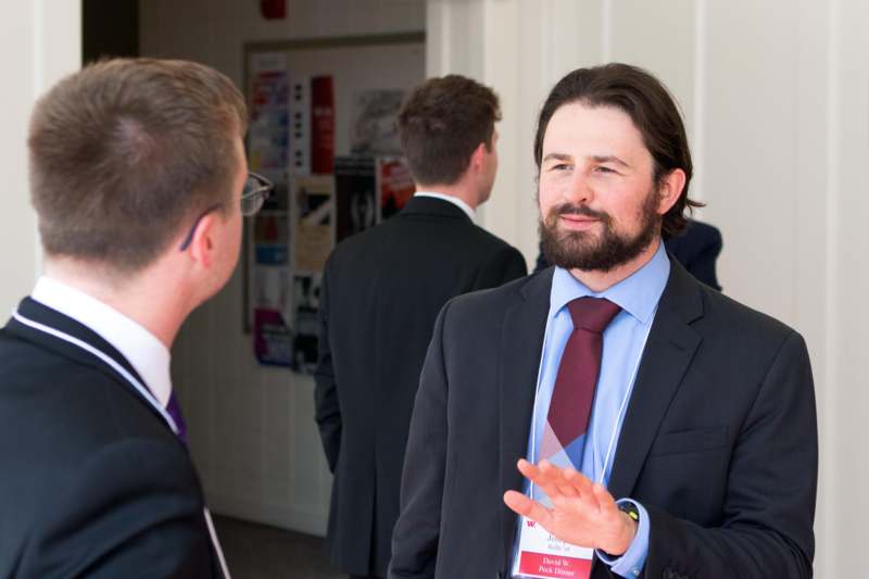 a man in a suit talking to another man