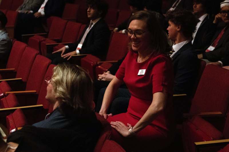 a woman in a red dress sitting in a theater