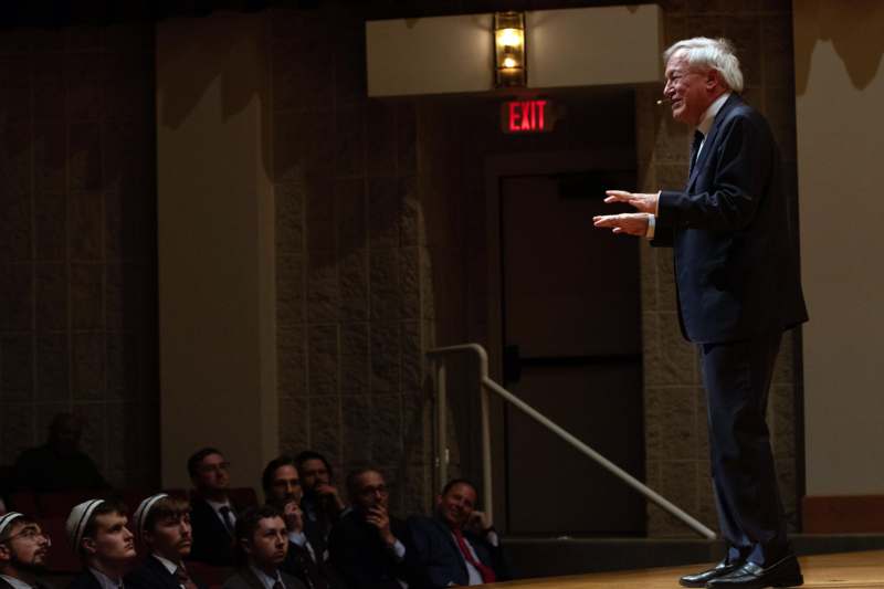 a man standing on a stage with a cigarette in his hand
