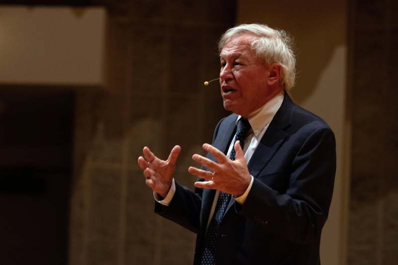 a man in a suit with a toothpick in his mouth