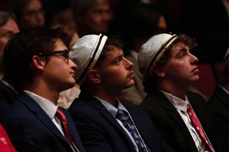 a group of men sitting in a row