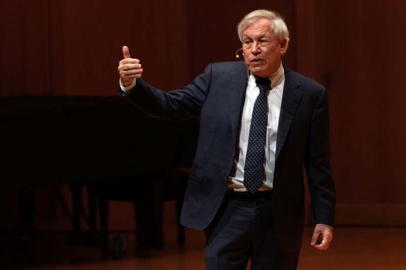 a man in a suit giving a thumbs up