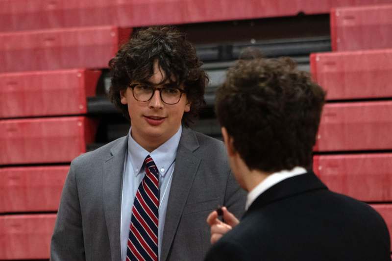 a man in a suit talking to another man