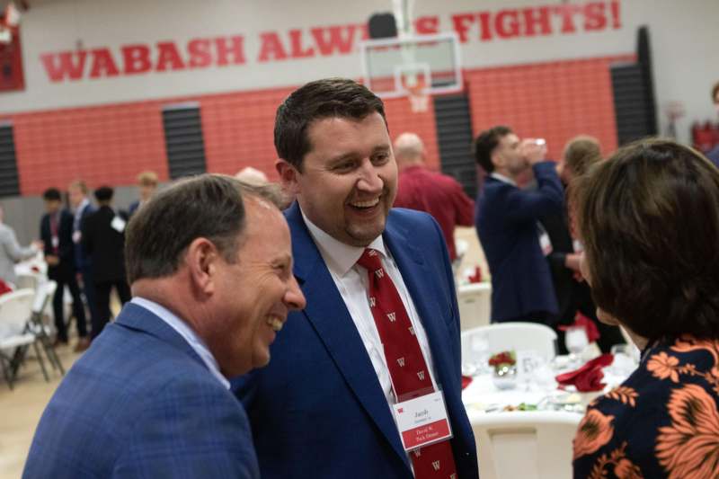 a group of men in suits and ties laughing