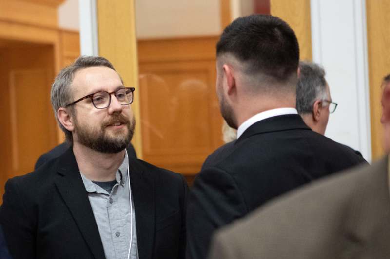 a man in a suit talking to another man