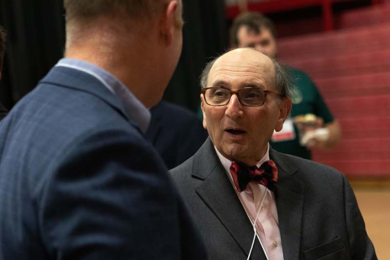 a man in a suit talking to another man