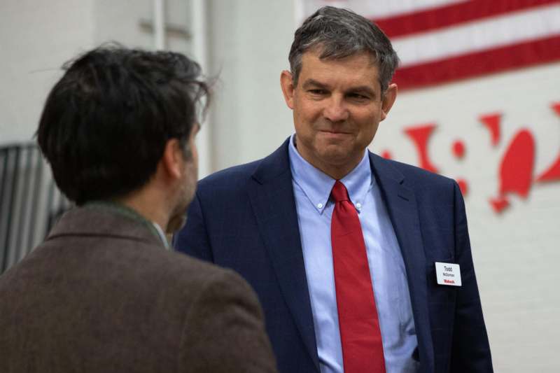 a man in a suit and tie talking to another man