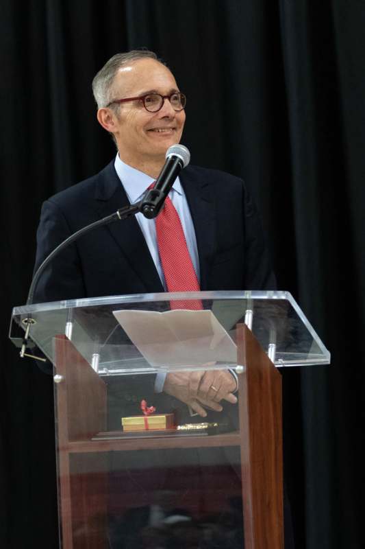 a man standing at a podium with a microphone