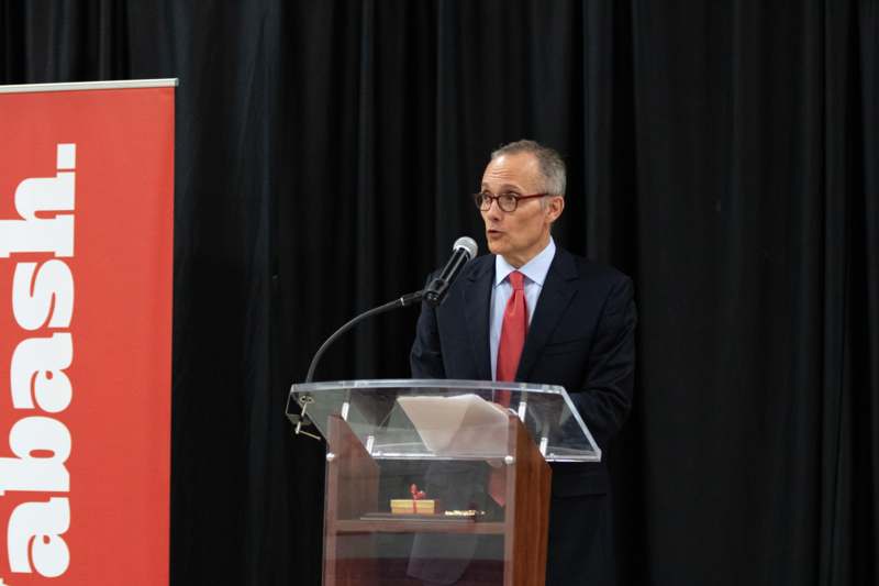 a man standing at a podium speaking into a microphone