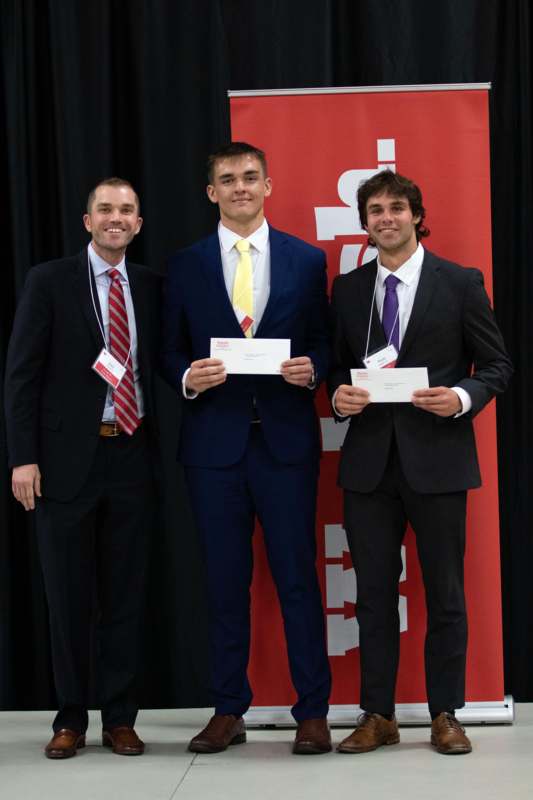 a group of men in suits holding certificates