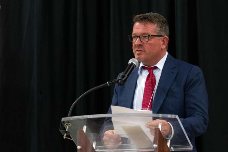 a man in a suit speaking into a microphone