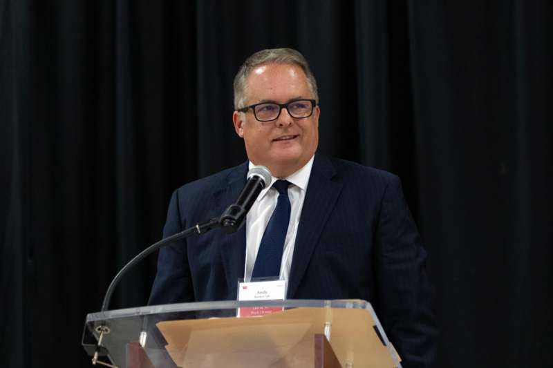 a man standing at a podium with a microphone
