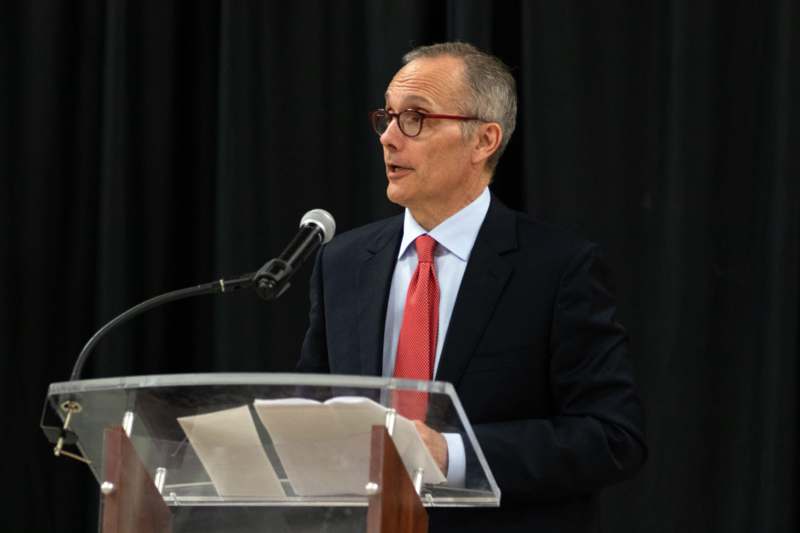 a man standing at a podium speaking into a microphone