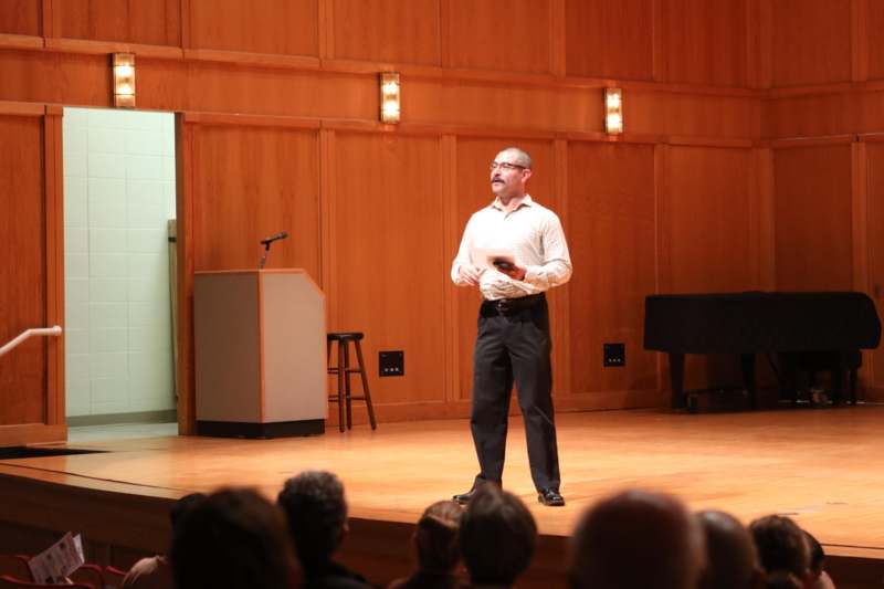 Visiting Artist Series: The Mexican Folkloric Dance Company of Chicago - a man standing on a stage holding a paper