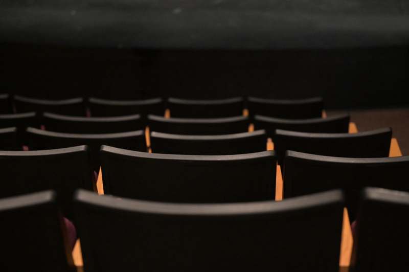 a row of black chairs in a theater