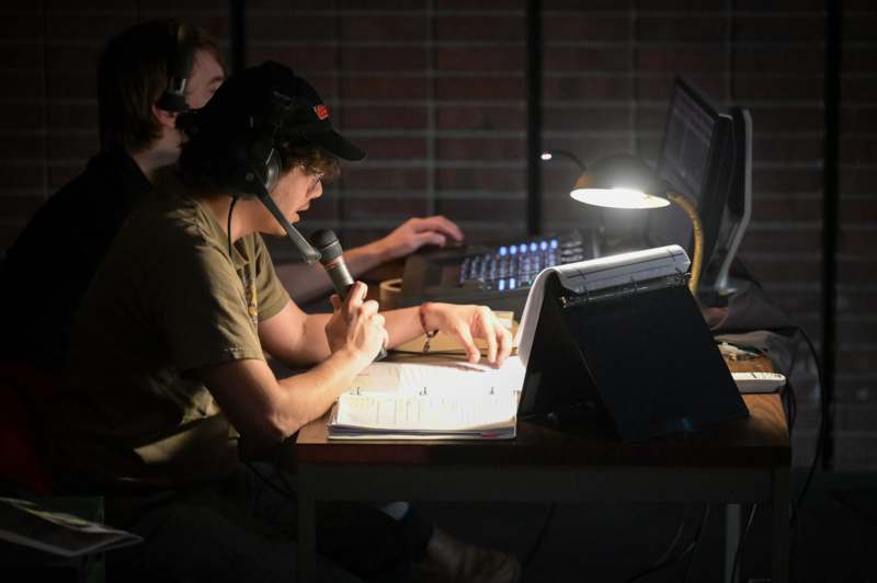 a man sitting at a desk with a microphone
