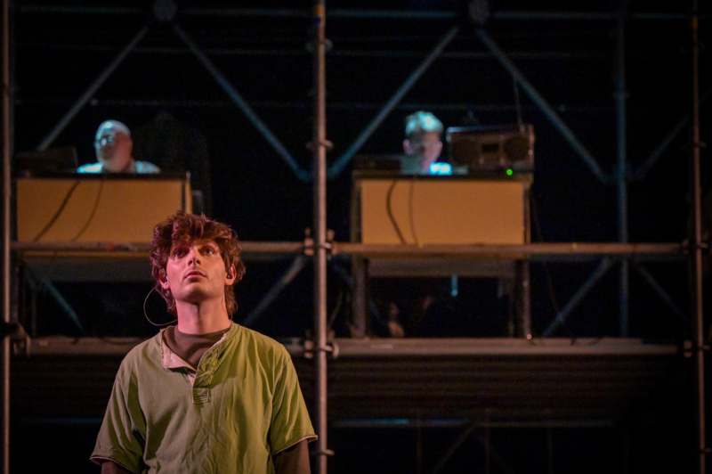 a man looking up at a man in a green shirt