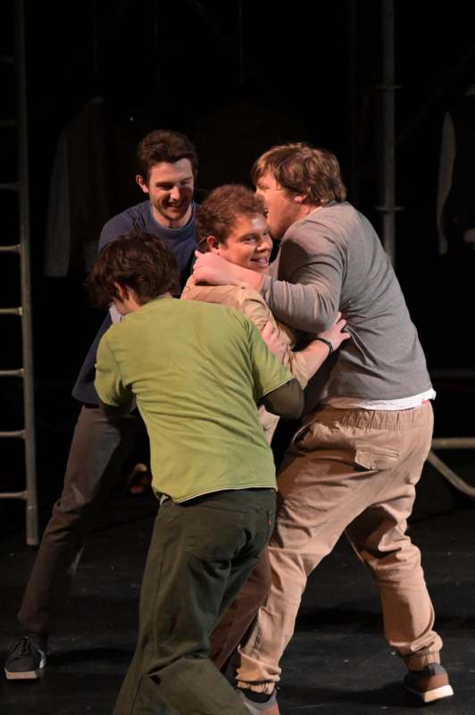 a group of men hugging on a stage